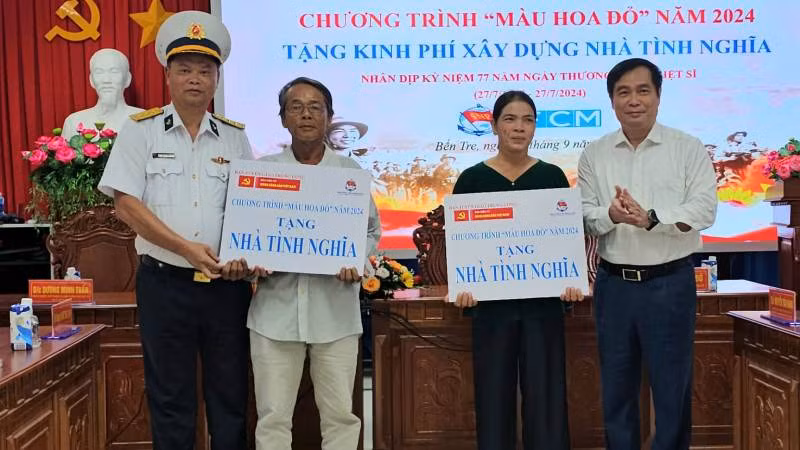 Lãnh đạo tham dự buổi lễ trao bảng tượng trưng hỗ trợ kinh phí xây dựng nhà tình nghĩa cho 2 hộ dân. (Ảnh: HOÀNG TRUNG)