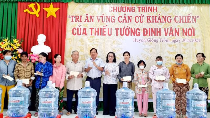 Lãnh đạo chính quyền địa phương trao quà, nước khoáng cho gia đình chính sách.