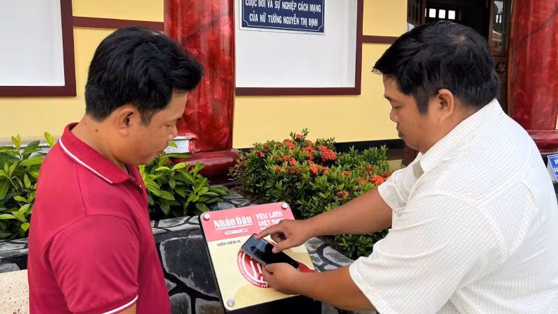 Khách du lịch trải nghiệm kết nối với trạm tương tác thông minh bằng điện thoại. (Ảnh: HOÀNG TRUNG).