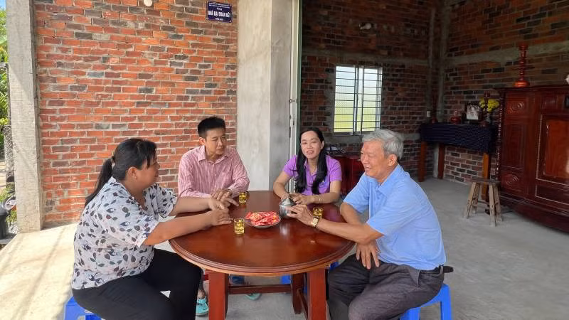 Ông Phạm Văn Được (giữa) bên căn nhà mới. (Ảnh: HOÀNG TRUNG)