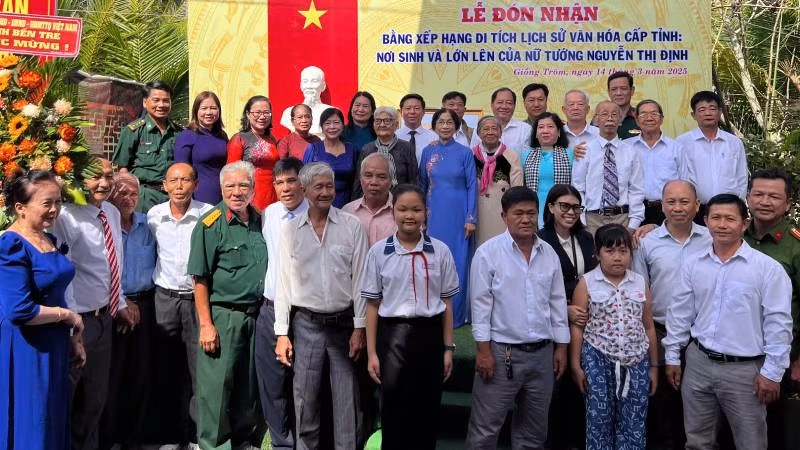 Lãnh đạo chính quyền địa phương cùng người thân trong gia đình Nữ tướng Nguyễn Thị Định chụp ảnh lưu niệm tại buổi lễ. (Ảnh: HOÀNG TRUNG)