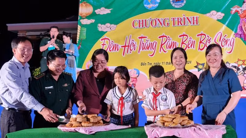 Đại biểu tham dự Chương trình cùng các cháu thiếu nhi thực hiện nghi thức Phá cỗ Trung thu. (Ảnh: MINH NGỌC)