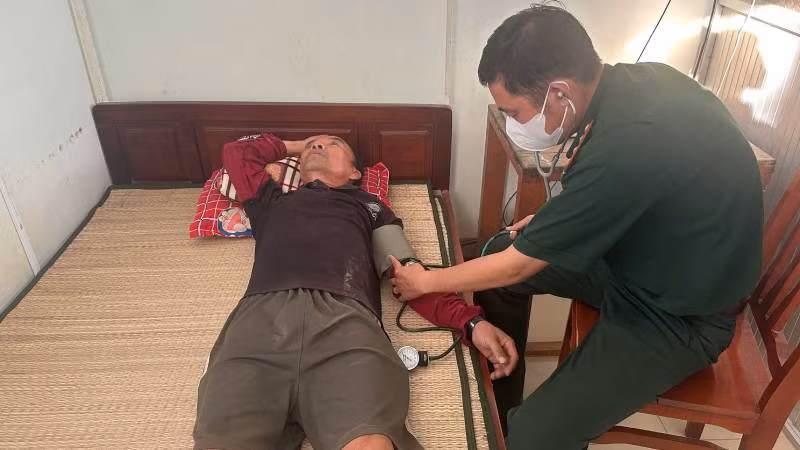 Bác sĩ Đồn Biên phòng Hàm Luông kiểm tra sức khỏe thuyền viên. (Ảnh: HOÀNG TRUNG)