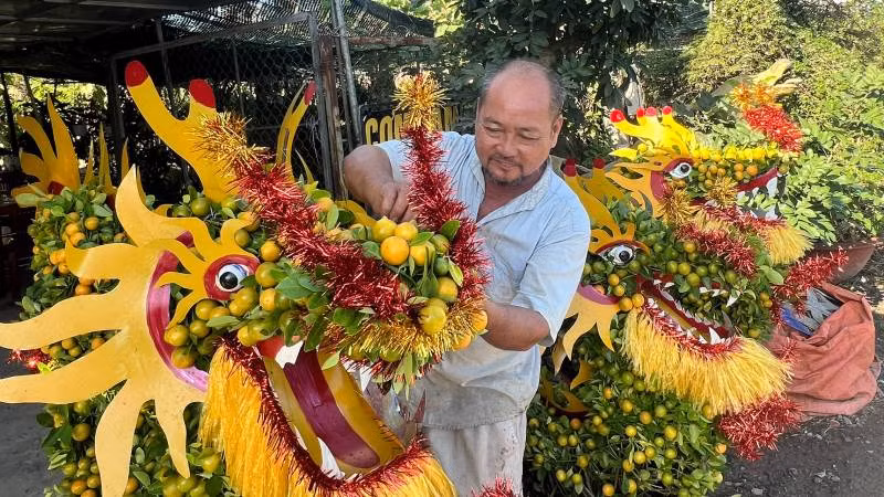 Nghệ nhân Nguyễn Văn Dị (xã Hưng Khánh Trung B, huyện Chợ Lách, tỉnh Bến Tre) hoàn tất sản phẩm quất hình rồng bán cho khách hàng.