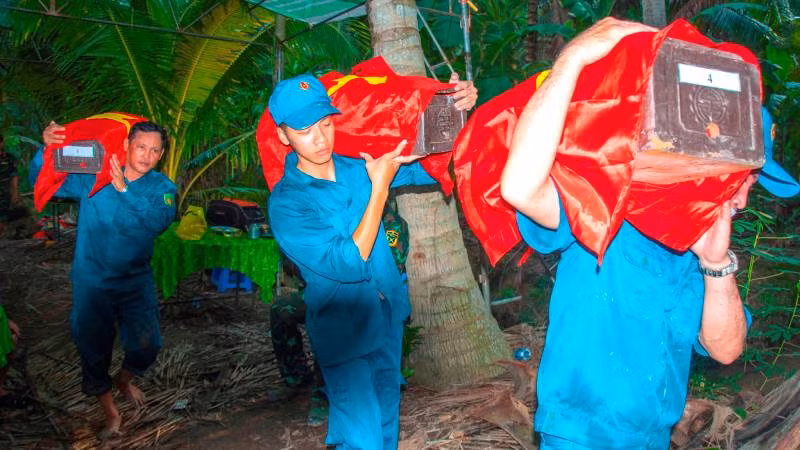 Lực lượng chức năng khai quật và cất bốc hài cốt liệt sĩ.