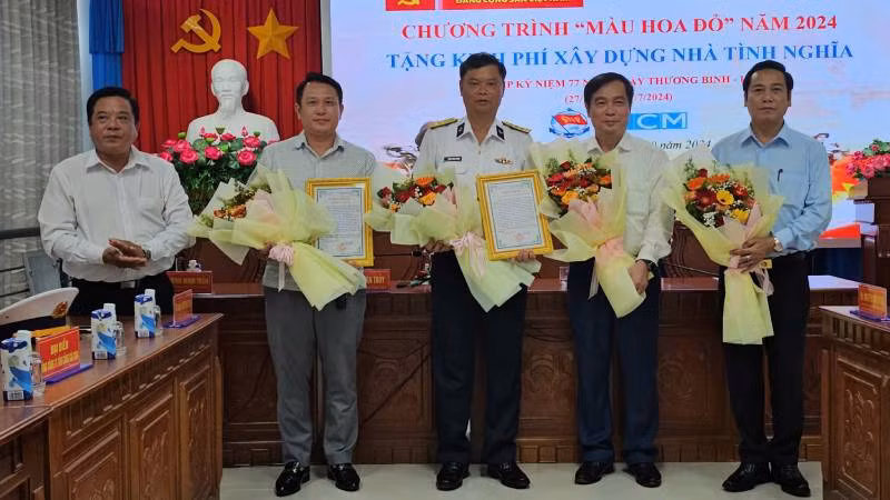 Lãnh đạo huyện Mỏ Cày Nam trao hoa, thư cám ơn cho các đơn vị tài trợ. (Ảnh: HOÀNG TRUNG)