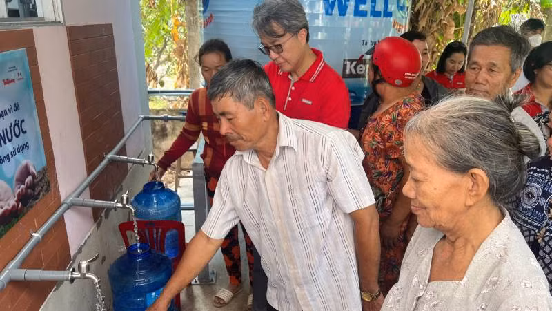 Người dân vui mừng đến nhận nước ngọt miễn phí.