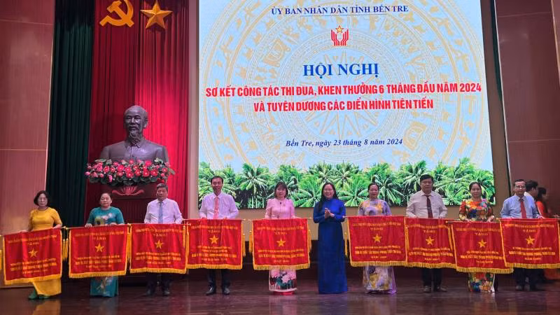 Lãnh đạo tỉnh Bến Tre trao cờ thi đua cho các đơn vị có thành tích xuất sắc. (Ảnh: HOÀNG TRUNG)