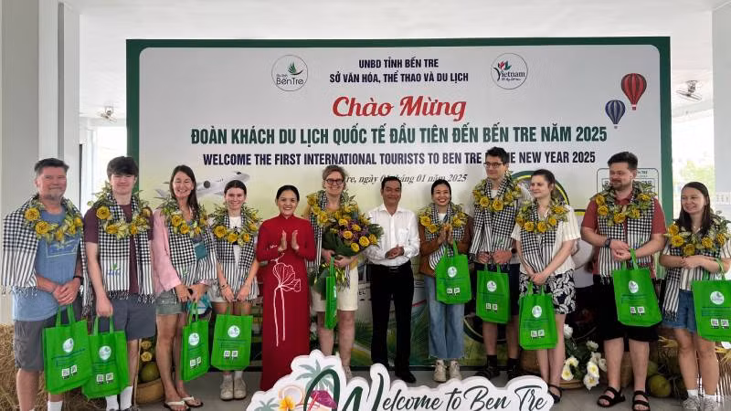 Lãnh đạo Sở Văn hóa, Thể thao và Du lịch tỉnh Bến tre tặng quà cho đoàn khách quốc tế đầu tiên đến Bến Tre năm 2025. (Ảnh: HOÀNG TRUNG)