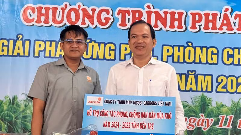 Đại diện Công ty Trách nhiệm hữu hạn Một thành viên JACOBI CARBONS Việt Nam trao bảng tượng trưng hỗ trợ công tác phòng, chống hạn mặn tại tỉnh Bến Tre. (Ảnh: HOÀNG TRUNG)