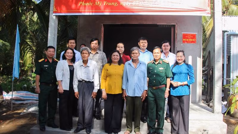 Đại diện lãnh đạo Bộ Quốc phòng cùng chính quyền địa phương bàn giao căn nhà tình thương cho hộ dân tại huyện Mỏ Cày Bắc. (Ảnh: HOÀNG TRUNG)