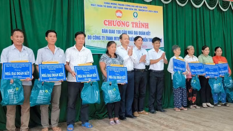 Đại diện nhà tài trợ cùng chính quyền địa phương trao bảng tượng trưng bàn giao nhà cho gia đình khó khăn về nhà ở. (Ảnh: HOÀNG TRUNG)