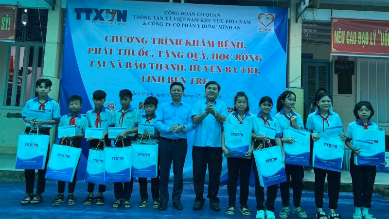 Lãnh đạo chính quyền địa phương cùng Ban tổ chức trao học bổng cho học sinh nghèo, vượt khó học giỏi. (Ảnh: HOÀNG TRUNG)