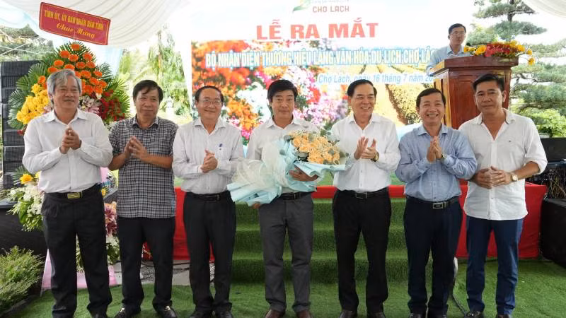 Lãnh đạo tỉnh Bến Tre tặng hoa chúc mừng trong buổi lễ ra mắt nhận diện thương hiệu Làng Văn hóa-Du lịch Chợ Lách. (Ảnh: HOÀNG TRUNG)