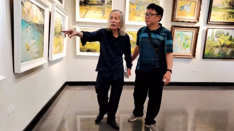 Họa sĩ Lương Xuân Đoàn, Chủ tịch Hội Mỹ thuật Việt Nam (bên trái) tại triển lãm.