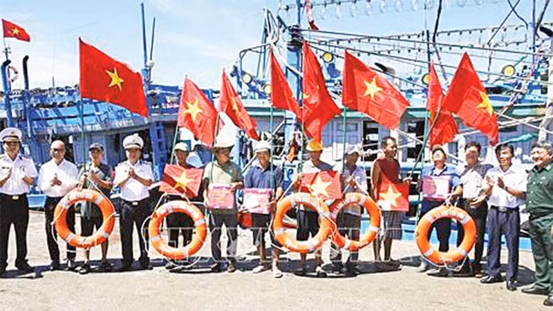 Bộ Tư lệnh Vùng 4 Hải quân trao cờ Tổ quốc, quà và phao cứu sinh cho ngư dân tại cảng cá Đá Bạc, thành phố Cam Ranh.