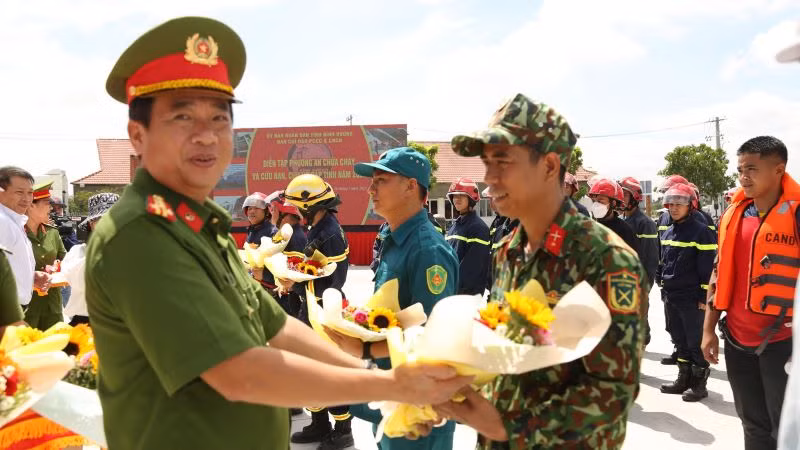 Đại tá Nguyễn Thanh Điệp, Phó Giám đốc Công an tỉnh Bình Dương và đại diện các ban, ngành của tỉnh trao tặng hoa chúc mừng các lực lượng phối hợp thực hiện buổi diễn tập.