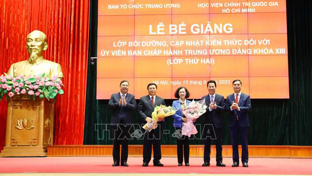 Ban tổ chức lớp tặng hoa cho đồng chí Trương Thị Mai và đồng chí Nguyễn Xuân Thắng. (Ảnh: TTXVN)
