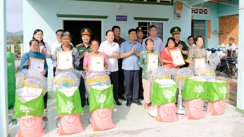 Bí thư Tỉnh ủy Kiên Giang Nguyễn Tiến Hải (thứ 5, từ trái qua) bàn giao nhà “Đại đoàn kết” và tặng quà cho người dân. (Ảnh: PHƯƠNG VŨ)