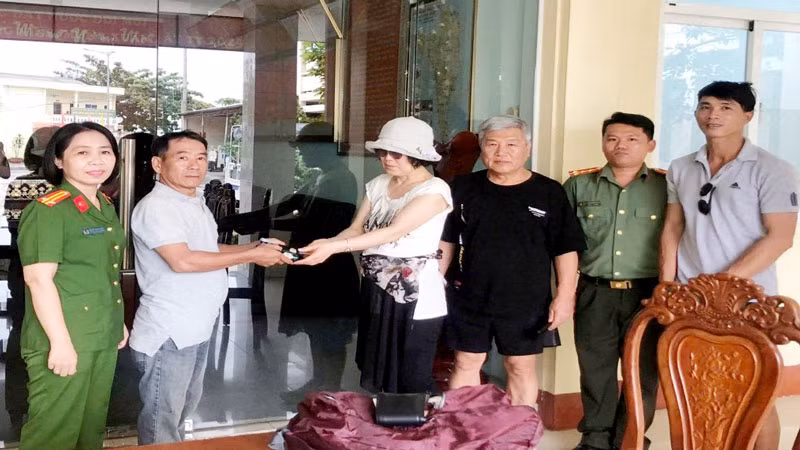 Vợ chồng du khách người Hàn Quốc (thứ 3 và 4, từ trái qua) nhận lại tài sản đã đánh rơi.