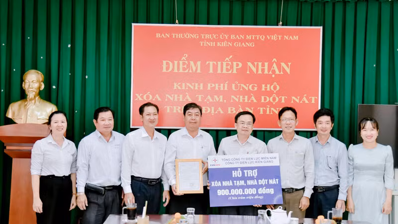 Lãnh đạo và nhân viên Công ty Điện lực Kiên Giang trao bảng tượng trưng hỗ trợ kinh phí xóa nhà tạm, nhà dột nát cho các hộ nghèo và hộ có hoàn cảnh khó khăn về nhà ở trên địa bàn tỉnh Kiên Giang.