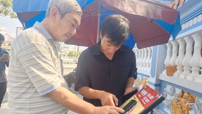 Người dân trải nghiệm công nghệ tại Di tích lịch sử quốc gia Mộ và Đình Nguyễn Trung Trực.