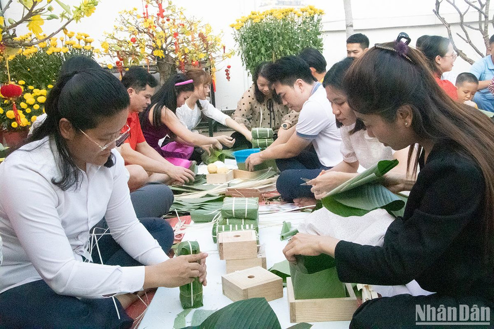 Khoảng 100 cán bộ, nhân viên người Việt Nam và Campuchia cùng tham gia gói bánh chưng. (Ảnh: Nguyễn Hiệp)