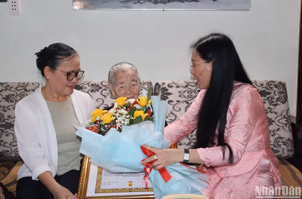 Bí thư Tỉnh ủy Quảng Ngãi Bùi Thị Quỳnh Vân trao chứng nhận Huy hiệu 80 tuổi Đảng và tặng hoa chúc mừng Mẹ Việt Nam Anh hùng Huỳnh Thị Thấm.