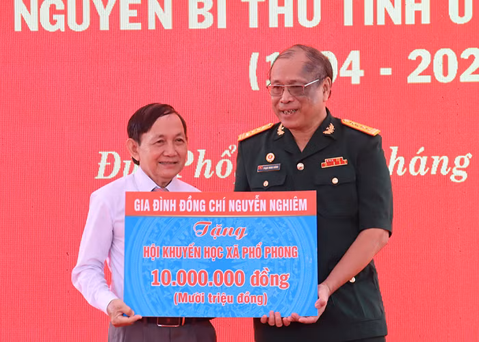 Đại diện gia đình đồng chí Nguyễn Nghiêm trao biểu trưng tặng 10 triệu đồng cho Hội Khuyến học xã Phổ Phong, thị xã Đức Phổ.