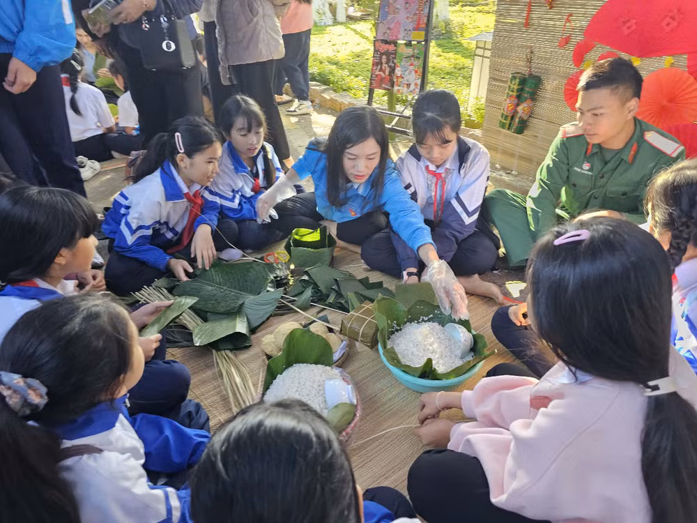 Các em thanh thiếu nhi tham gia trải nghiệm gói bánh chưng.