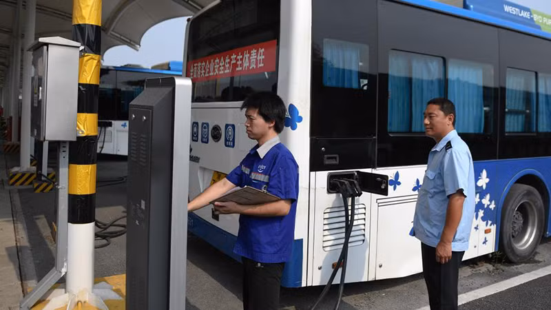 Kiểm tra xe buýt điện tại một trạm sạc ở thành phố Hàng Châu. Ảnh: (Tân Hoa Xã)