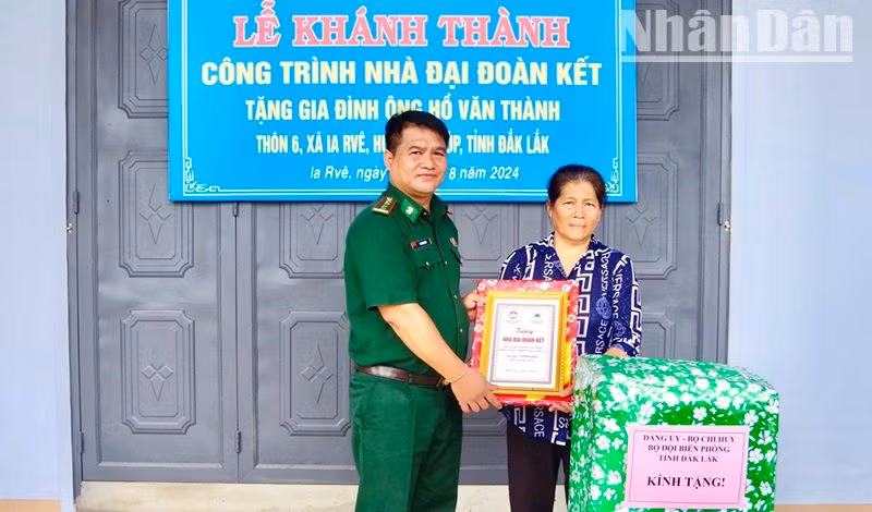 Đại tá Rơ Lan Ngân, Phó Chính ủy Bộ đội Biên phòng tỉnh Đắk Lắk trao biểu trưng và quà tặng gia đình ông Hồ Văn Thành.