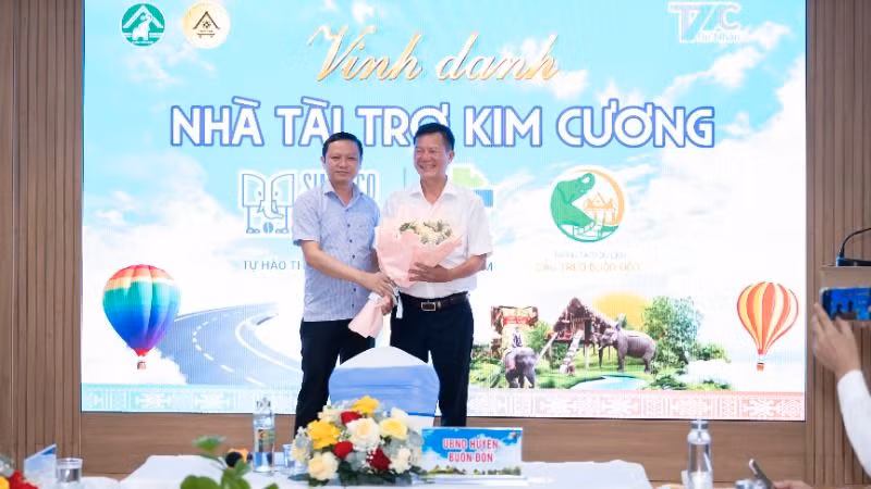 Chủ tịch Ủy ban nhân dân huyện Buôn Đôn Phạm Trung Nghĩa tặng hoa cảm ơn nhà tài trợ kim cương Ngày hội Khinh khí cầu Đắk Lắk 2025 - Bay trên đại ngàn cho đại diện Công ty trách nhiệm hữu hạn một thành viên xuất nhập khẩu 2/9 Đắk Lắk.