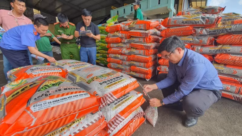 Cơ quan chức năng lấy mẫu phân bón của Công ty cổ phần thương mại phân bón Nam Dương và Công ty cổ phần Tập đoàn Phân bón quốc tế Hoa Kỳ - VINA đi giám định.