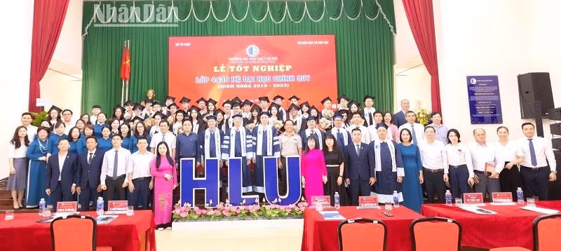 Các tân cử nhân ngành Luật chụp hình lưu niệm với lãnh đạo Trường Đại học Luật Hà Nội và các đại biểu.