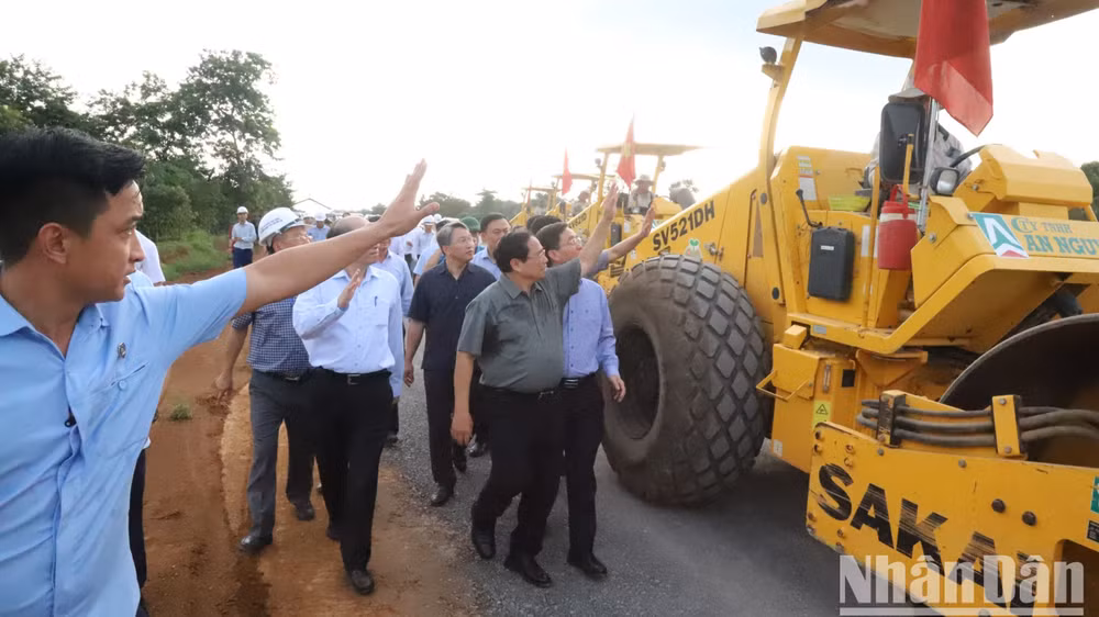 Thủ tướng chào hỏi công nhân lái xe thi công trên công trường.