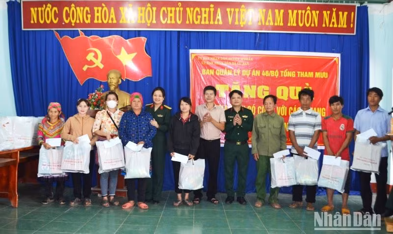 Đại diện Ban Quản lý dự án 46 và chính quyền địa phương trao tặng quà cho các gia đình chính sách, hộ nghèo trên địa bàn xã Cư San, huyện M’Đrắk.