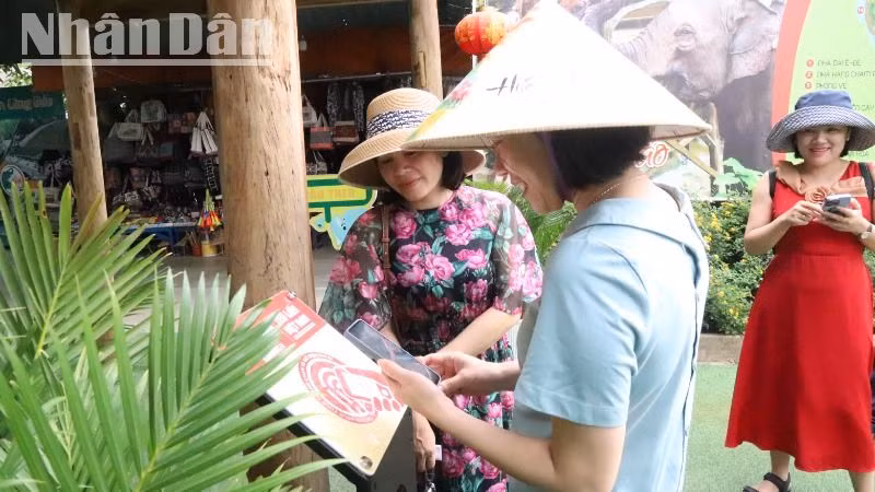 Du khách phấn khởi khi trải nghiệm tìm hiểu về Trung tâm Du lịch Cầu treo Buôn Đôn qua bảng gắn chip NFC (công nghệ kết nối không dây) thuộc Dự án “Yêu lắm Việt Nam” do Báo Nhân Dân phối hợp các đối tác công nghệ triển khai thực hiện.