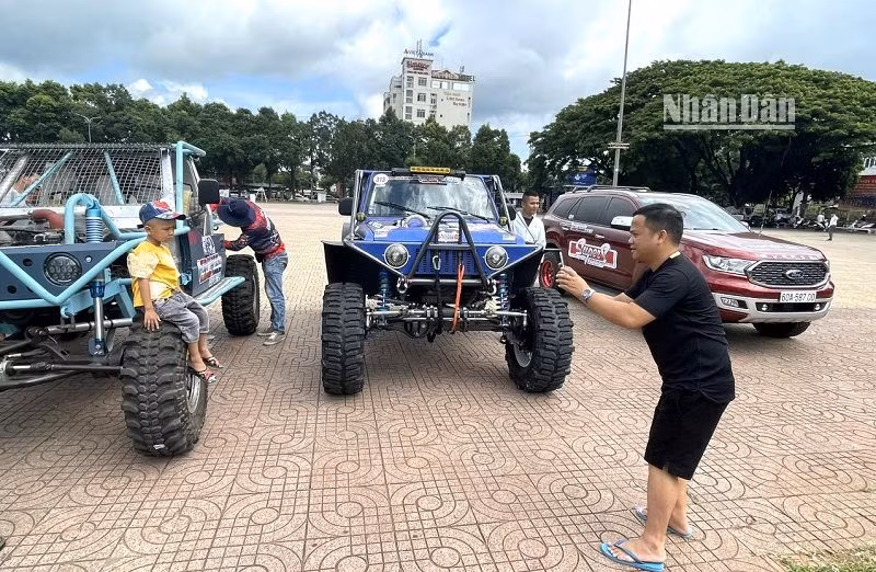 Người hâm mộ xe đua địa hình ở Đắk Lắk đưa con đến chụp hình bên xe đua làm kỷ niệm.