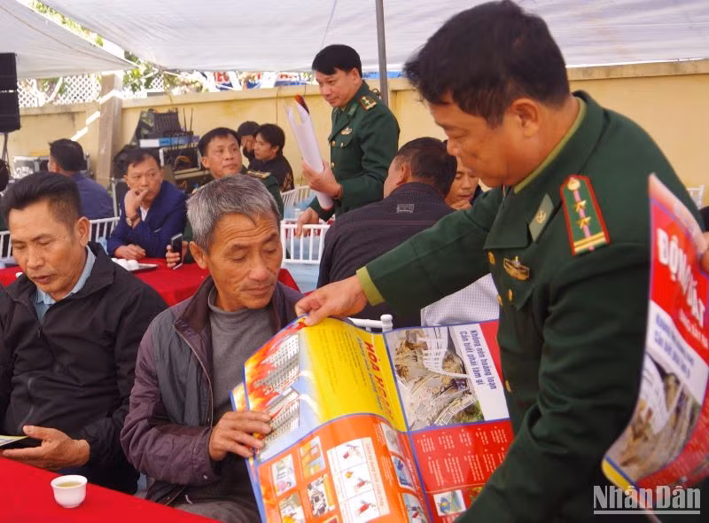Bộ đội Biên phòng tỉnh Thái Bình phát tờ rơi hướng dẫn phòng chống hỏa hoạn trên tàu cá cho ngư dân.
