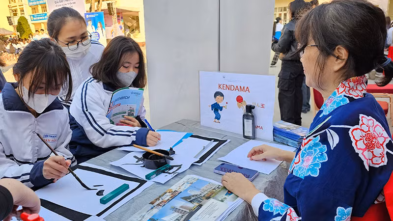 Học sinh tìm hiểu cơ hội du học và trải nghiệm viết chữ Nhật Bản.