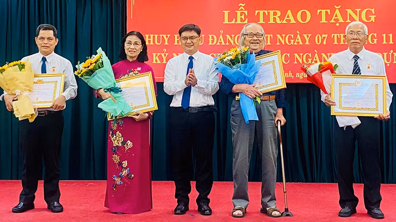 Đồng chí Nguyễn Mạnh Cường, Trưởng ban Dân vận Thành ủy Thành phố Hồ Chí Minh trao tặng Huy hiệu 45 năm tuổi Đảng và Huy hiệu 40 năm tuổi Đảng cho các đảng viên.