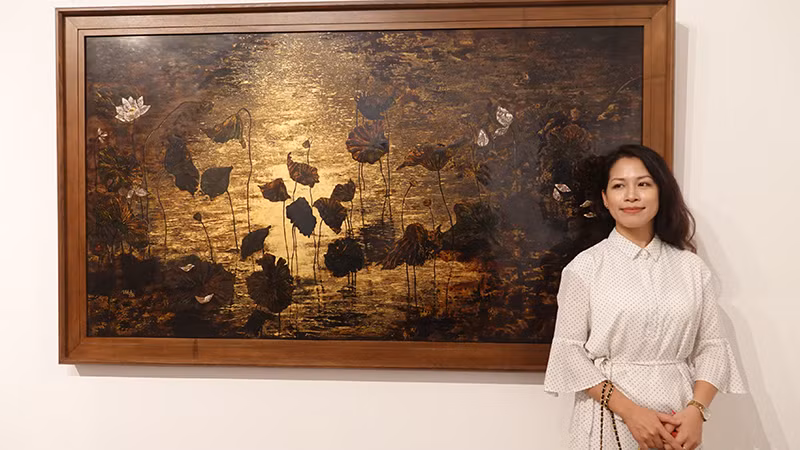 Họa sĩ Trịnh Quế Anh bên tác phẩm của mình.