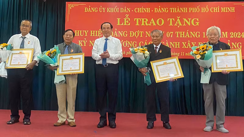 Đồng chí Nguyễn Văn Nên, Ủy viên Bộ Chính trị, Bí thư Thành ủy Thành phố Hồ Chí Minh trao Huy hiệu 55 năm tuổi Đảng và Huy hiệu 50 năm tuổi Đảng cho các đảng viên.