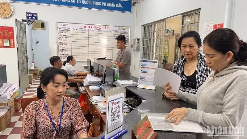 Công chức, viên chức Ủy ban nhân dân phường 4 (quận Gò Vấp) hướng dẫn người dân thực hiện thủ tục hành chính sáng 15/2.