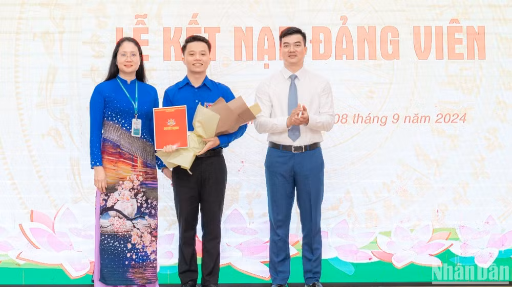 Đồng chí: Nguyễn Thị Hồng, Bí thư Đảng ủy; Nguyễn Anh Tuấn, Đảng ủy viên, Phó Hiệu trưởng Nhà trường trao quyết định và tặng hoa chúc mừng Đảng viên mới tại buổi lễ