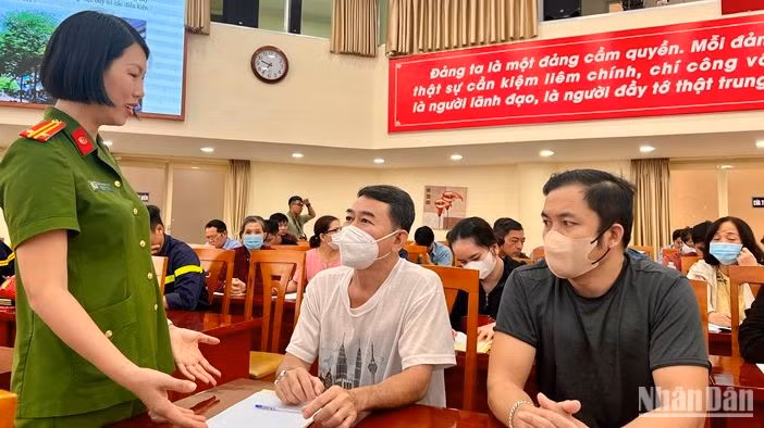 Trung tá Nguyễn Thị Hồng Thủy trao đổi cùng các chủ cơ sở trên địa bàn quận tại chương trình tập huấn.