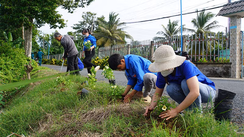 Trồng hoa trên tuyến đường nông thôn mới kiểu mẫu tại ấp 3, xã Đốc Binh Kiều. (Ảnh: HOÀNG KHA)