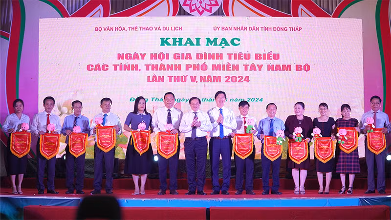 Đại diện 13 tỉnh, thành phố miền Tây Nam Bộ nhận cờ lưu niệm của ban tổ chức và Bé Sen - Biểu tượng quảng bá hình ảnh của tỉnh Đồng Tháp. (Ảnh: HỮU NGHĨA)