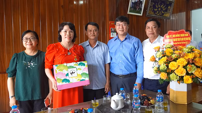Bí thư Tỉnh ủy Đồng Tháp Lê Quốc Phong (thứ 2 từ phải sang) thăm, tặng hoa chúc mừng nhà giáo ưu tú Võ Thị Hiền.